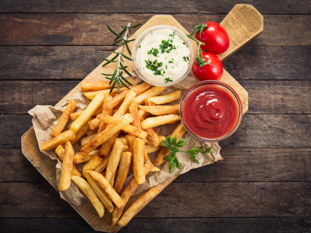 Картофель фри с соусом и кетчупом на доске