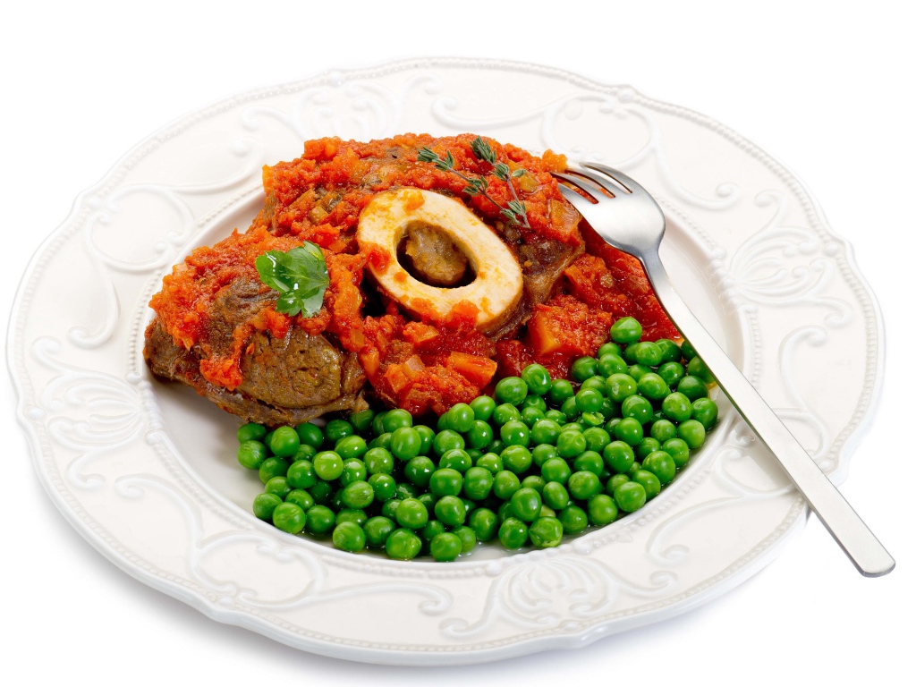 Зеленый горошек на белой тарелке с мясом