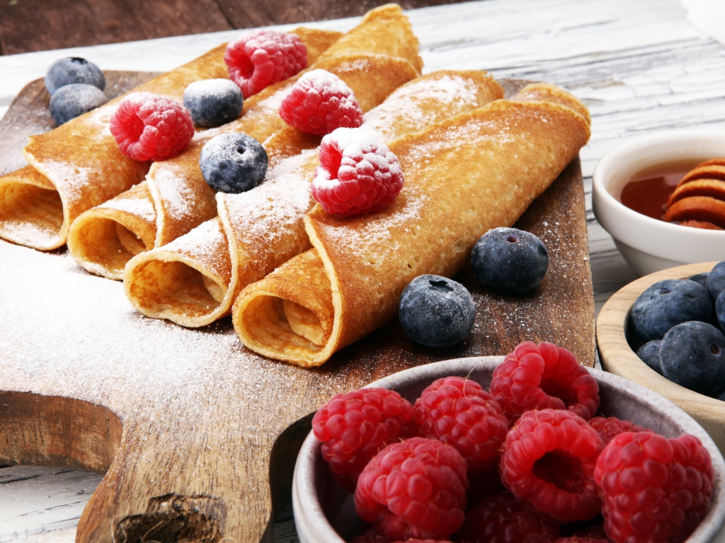 Блинчики с ягодами черники, малиной и сахарной пудрой