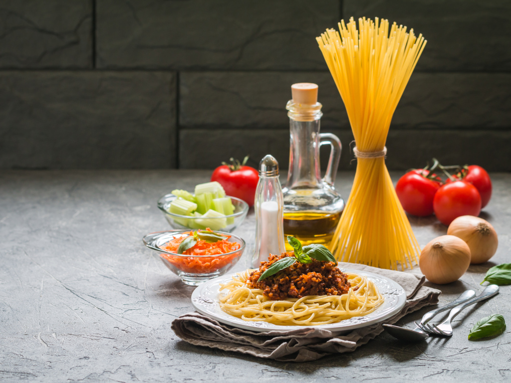 Паста с гарниром на столе с овощами и маслом