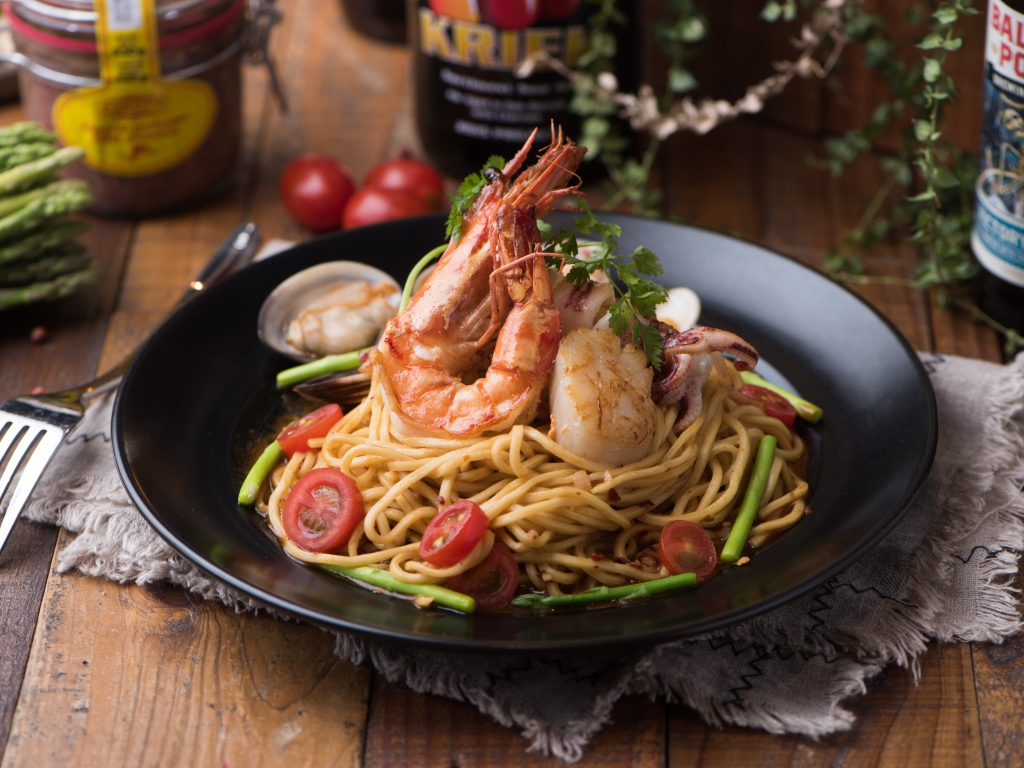 Спагетти с морепродуктами на черной тарелке