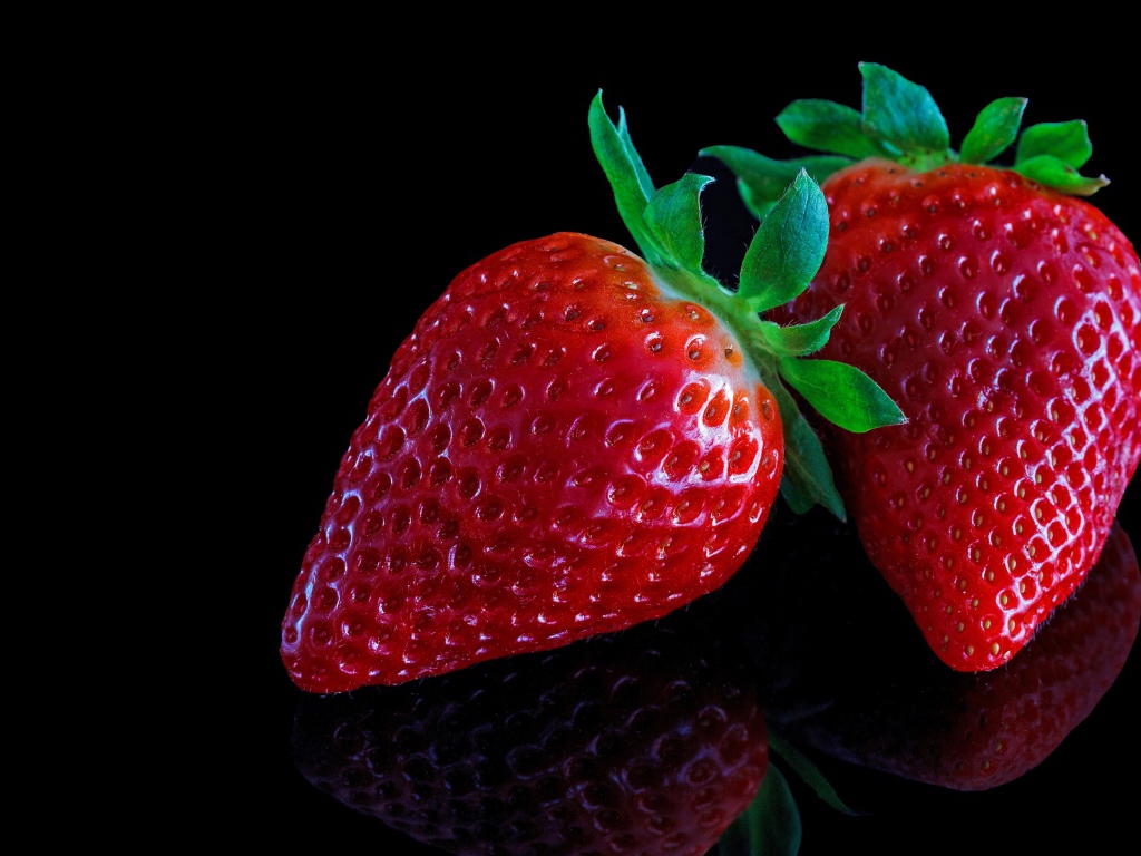 Красивая крупная красная клубника на черном  фоне