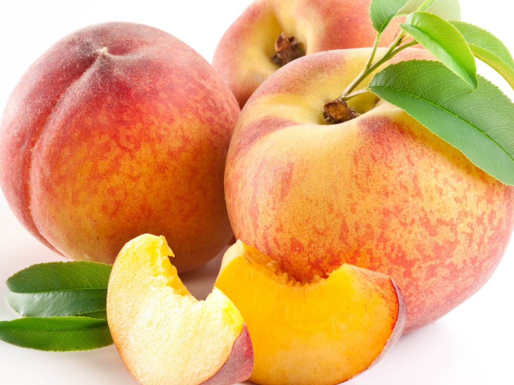 Крупные спелые сладкие персики на белом фоне
