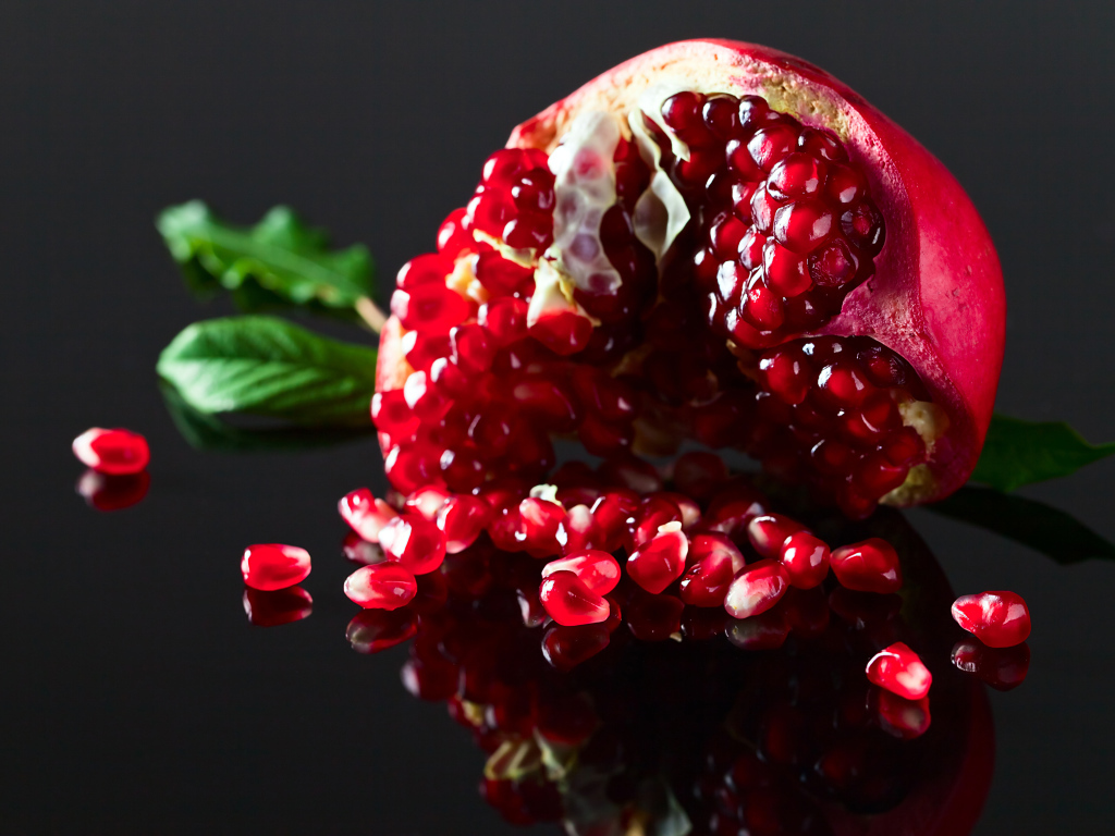 Чищенный гранат на сером фоне крупным планом