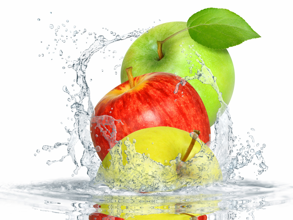 Три яблока в брызгах воды на белом фоне