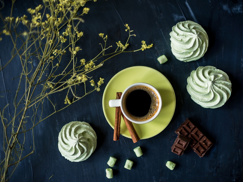 Чашка кофе с меренгой и шоколадом на столе