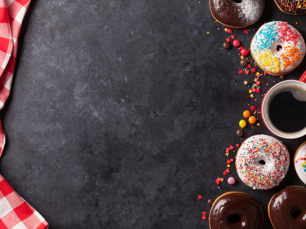 Аппетитные сладкие пончики с кофе на сером фоне