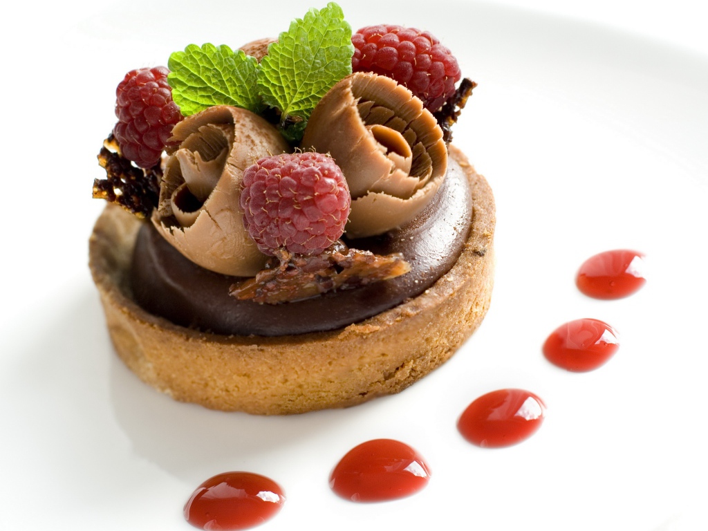 Пирожное с шоколадом и ягодами малины на белом фоне