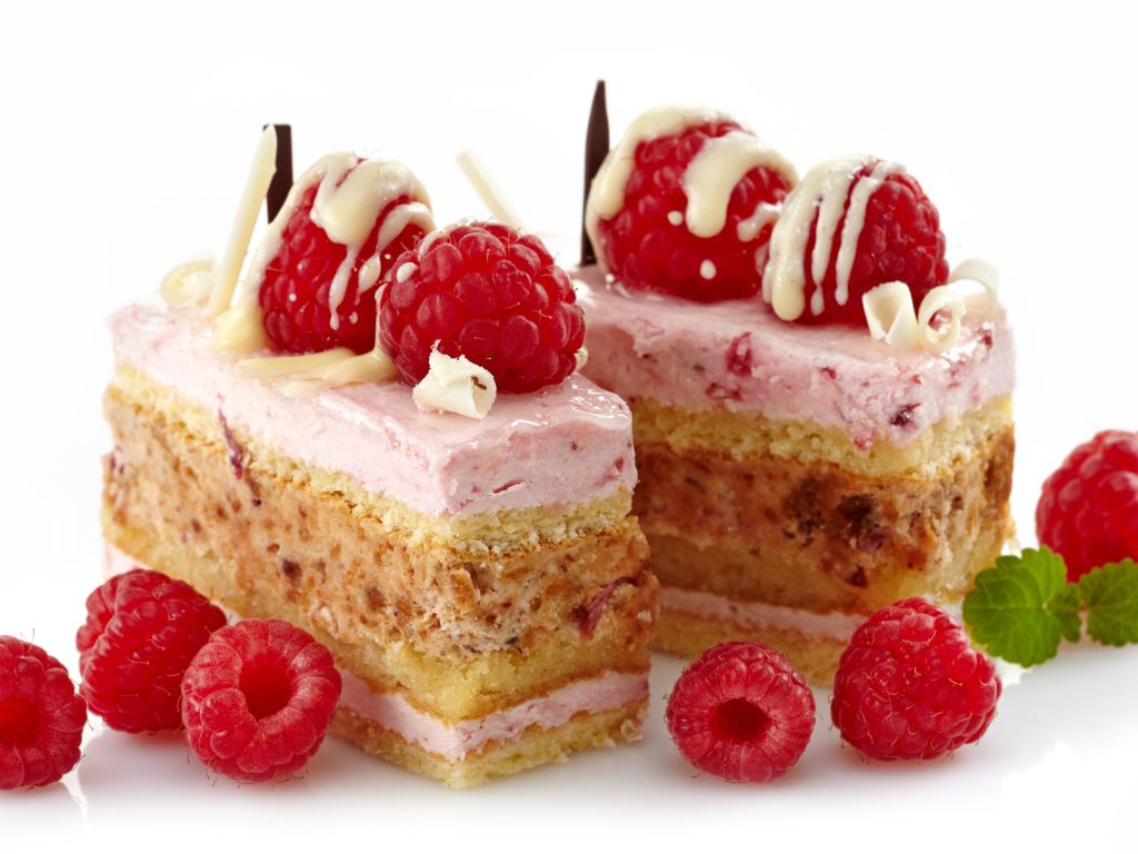 Пирожные с ягодами малины на белом фоне