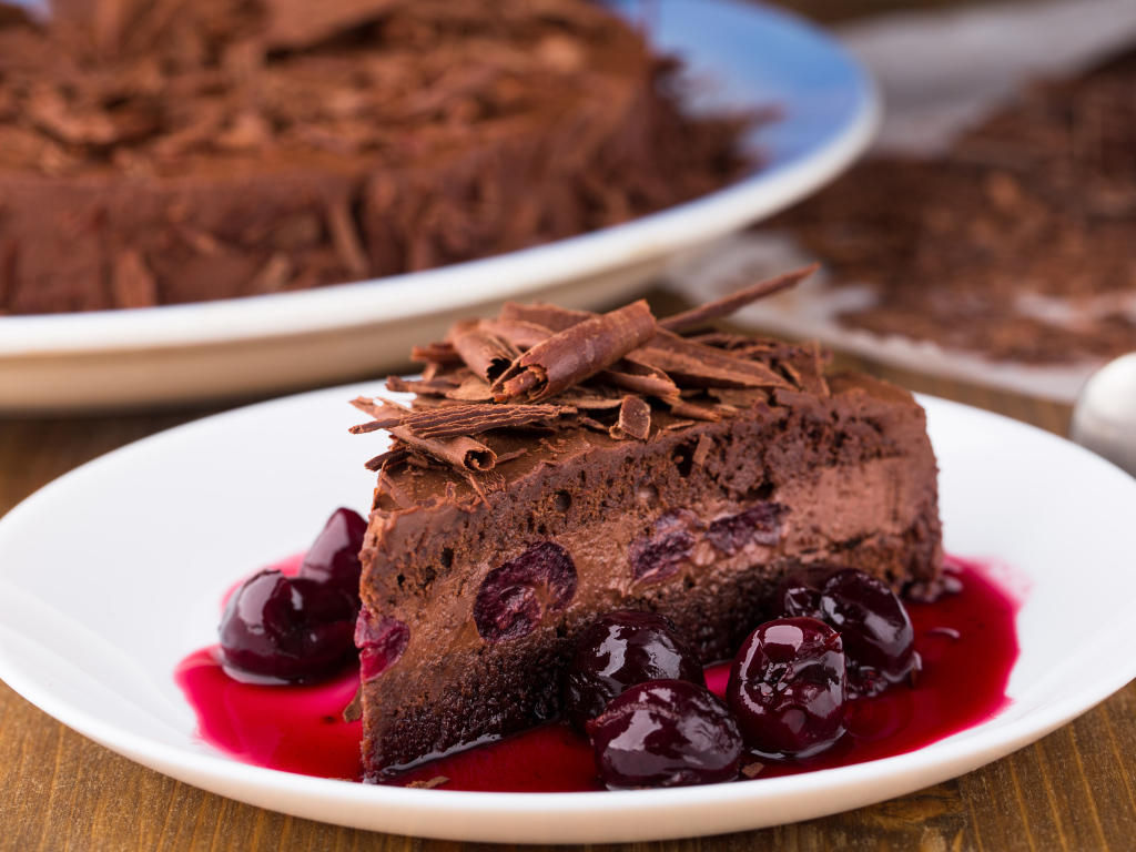 Шоколадный пирог с вишневым вареньем на белой тарелке