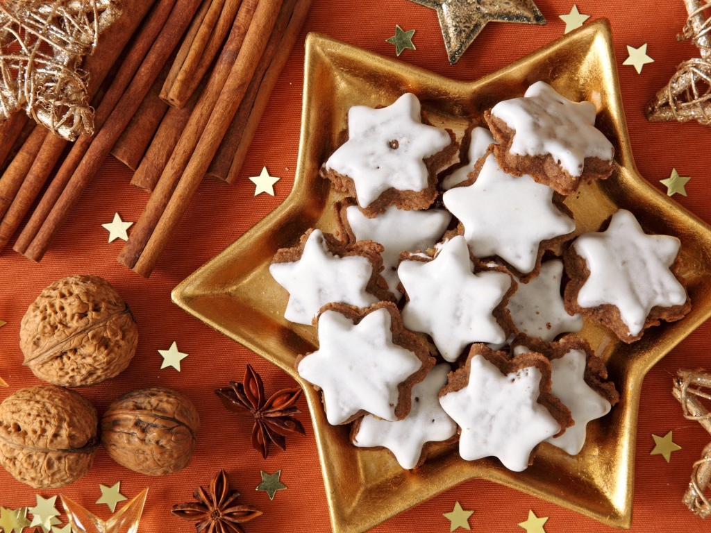 Печенье с глазурью на столе с орехами, корицей и бадьяном