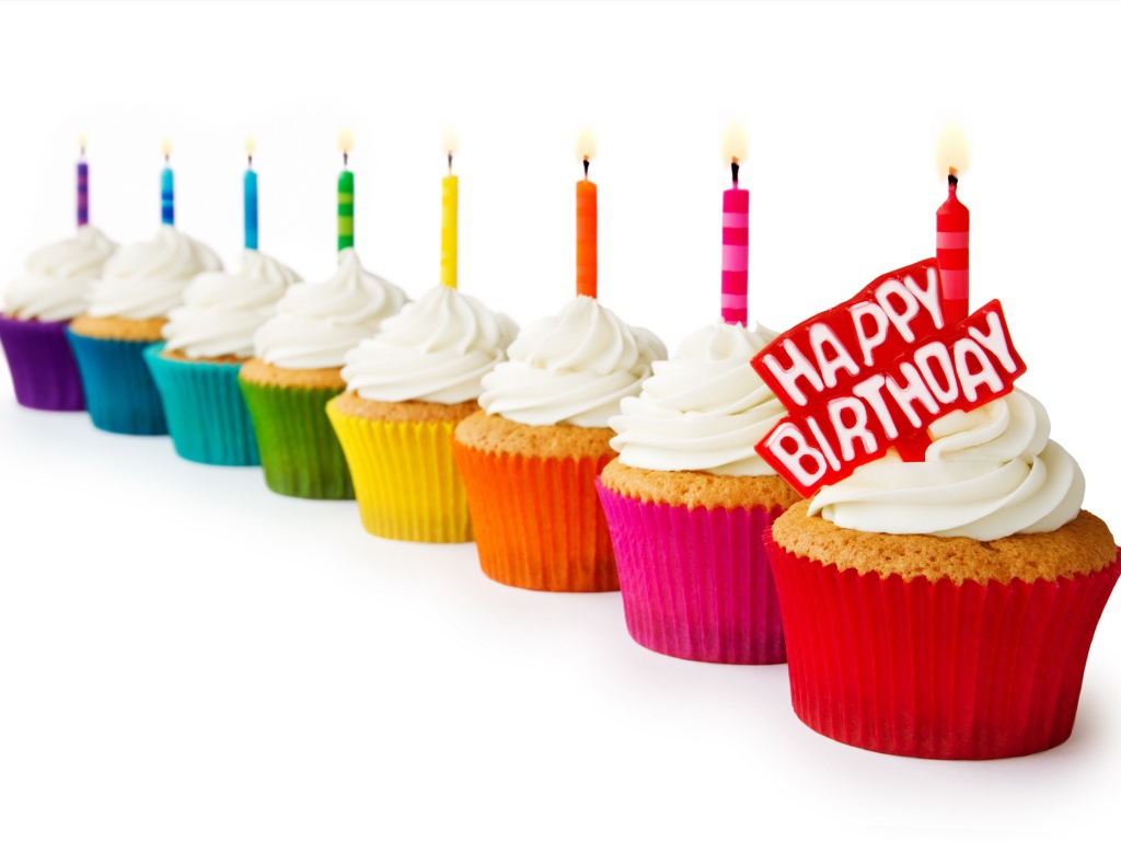 Cupcakes with candles and cream for birthday on a white background