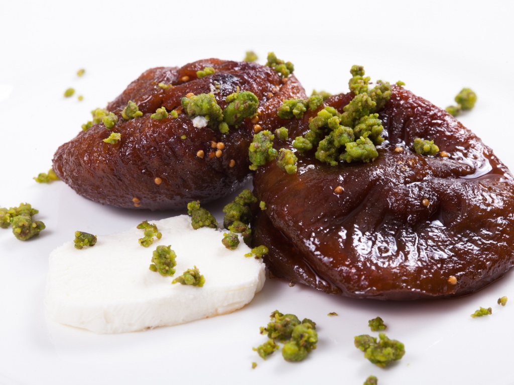 Инжир с фисташковыми орехами на белом фоне