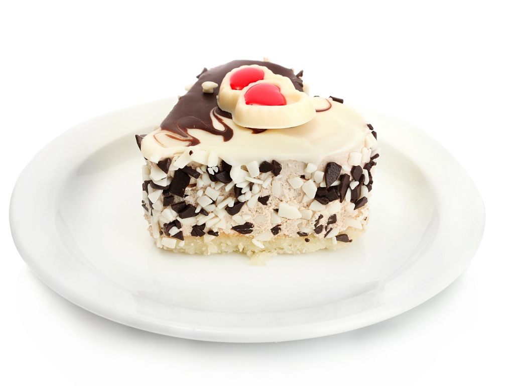 Пирожное в форме сердца с шоколадом на белой тарелке