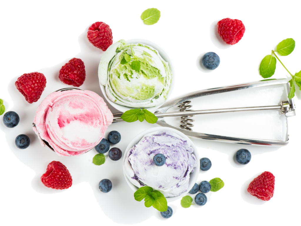 Шарики мороженого на столе с ягодами черники и малины 