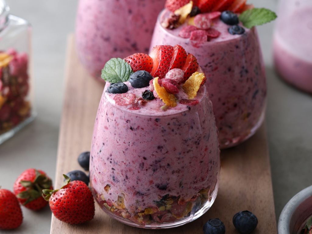 Сладкий десерт с ягодами в стаканах на столе