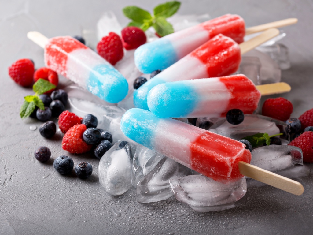 Трехцветное фруктовое мороженое лежит на кусочках льда