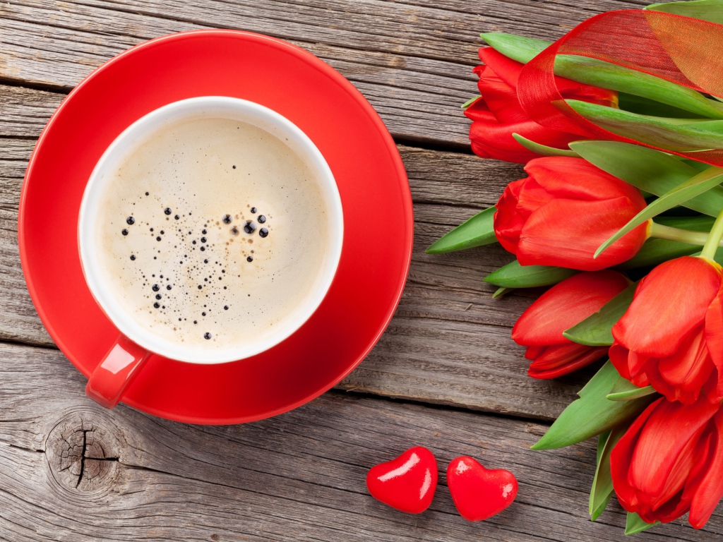 Чашка кофе с красными тюльпанами на деревянном столе 