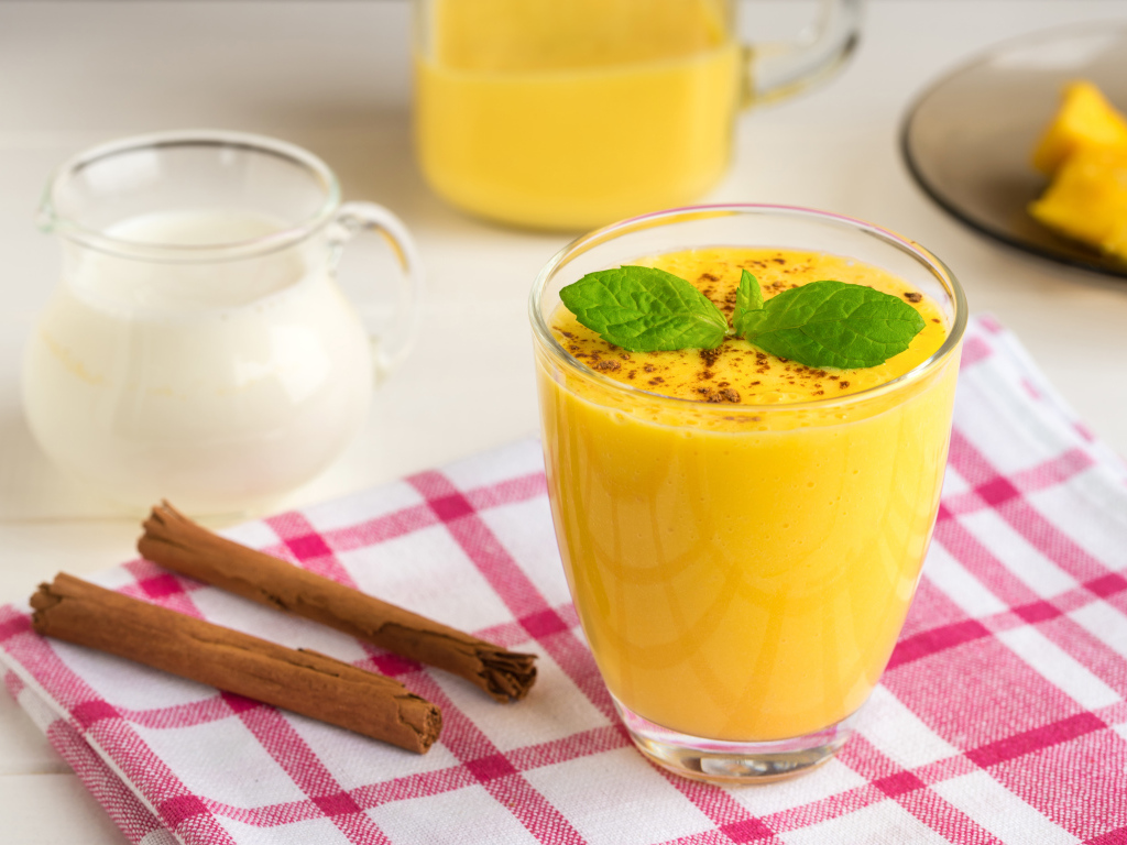 Стакан сока на столе с молоком и корицей