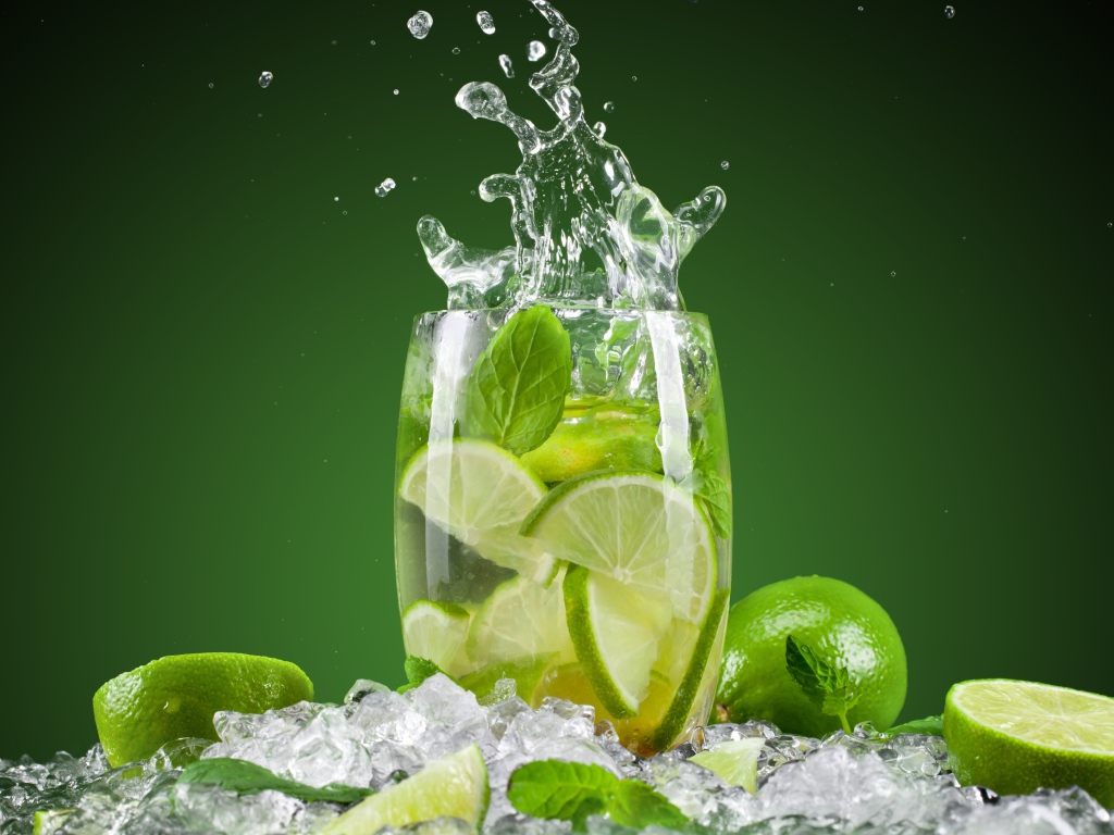 Стакан с лимонадом стоит на кусочках льда с лаймом