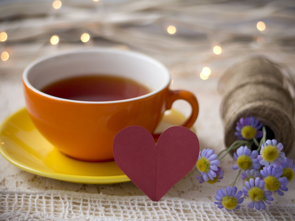 Большая чашка чая на столе с розовым бумажным сердцем и цветами