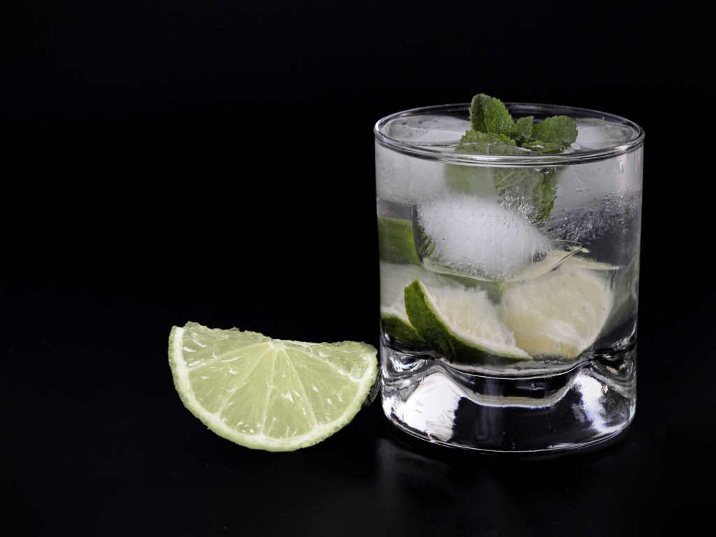 Коктейль кайпиринья на черном фоне с кусочком лайма