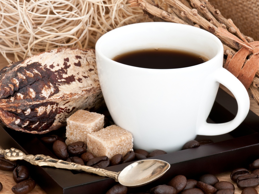 Белая чашка кофе с зернами и кусочками сахара на столе 