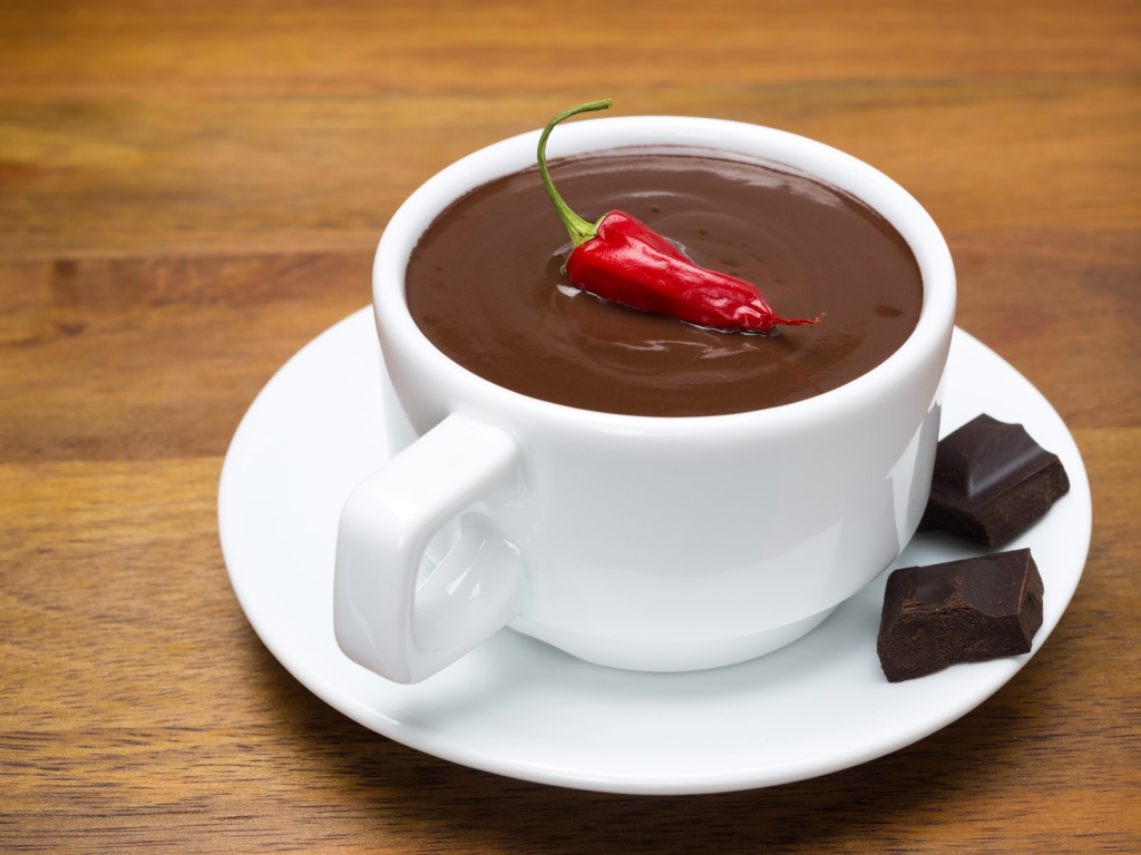 Белая чашка горячего шоколада с красным перцем