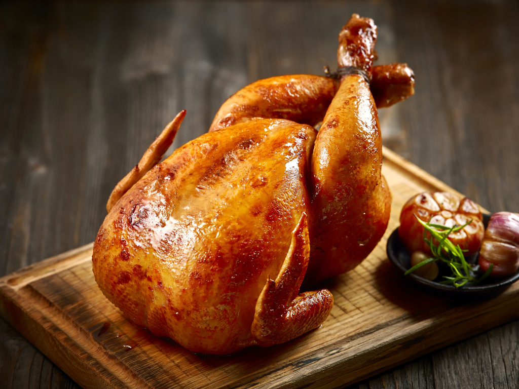 Аппетитная запеченная курица на разделочной доске