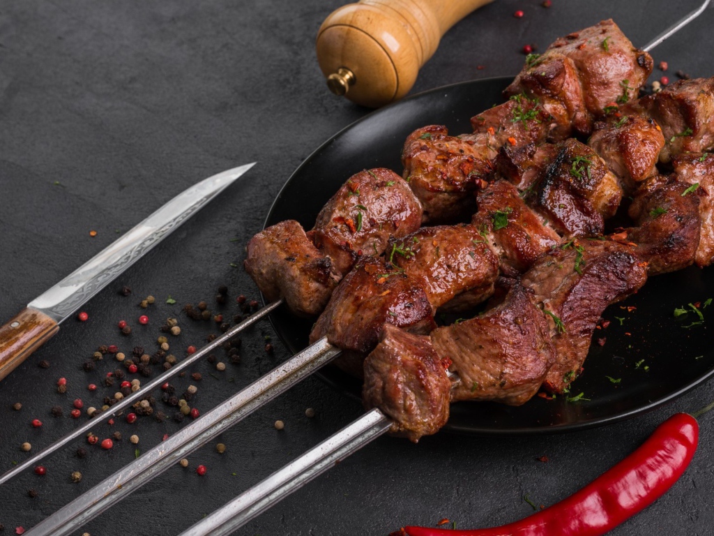 Appetizing meat shish kebab on a table with pepper