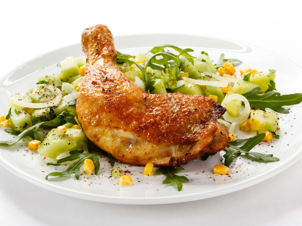 Куриный окорочок с салатом на белом фоне