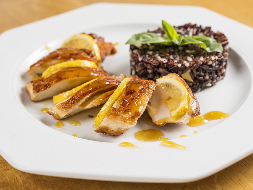 Куриный рулет на белой тарелке с рисом