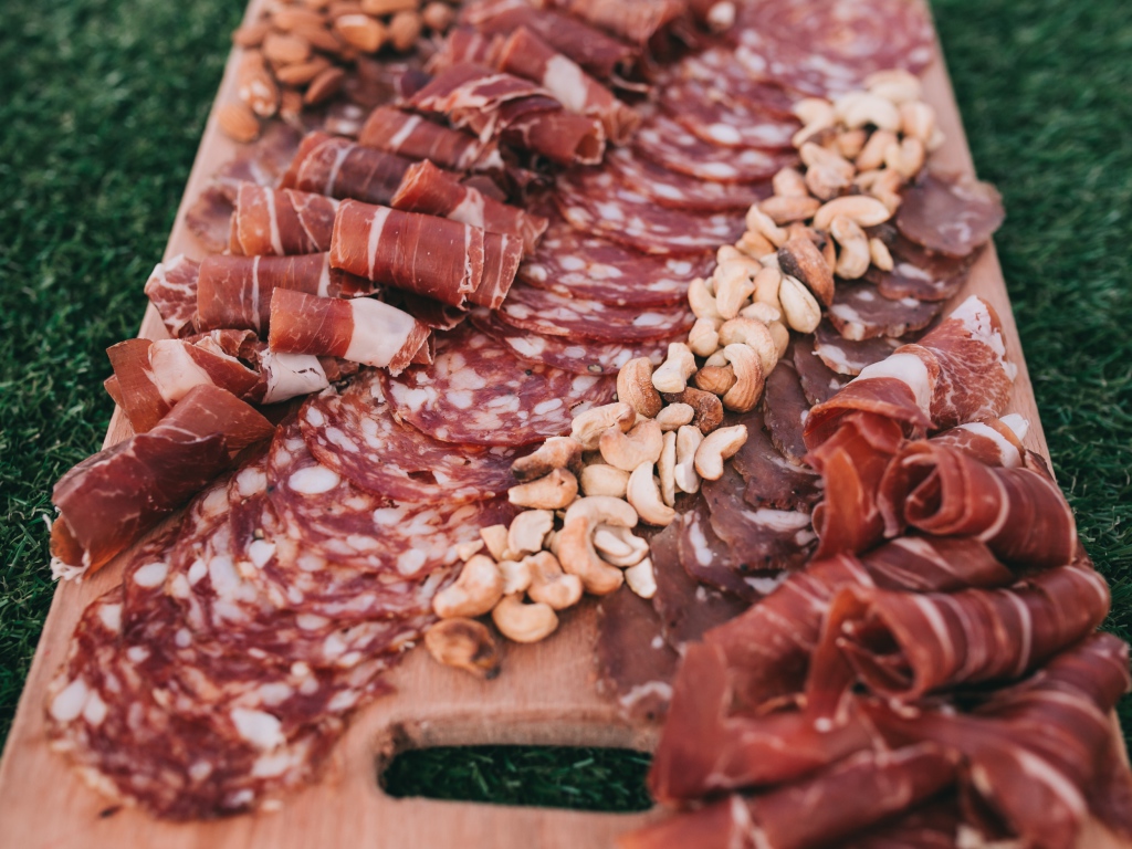 Мясная нарезка с орехами на разделочной доске