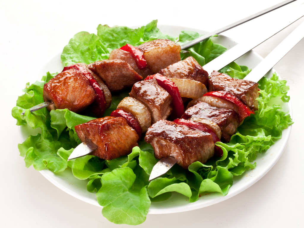 Аппетитный шашлык с листьями салата на шампурах 