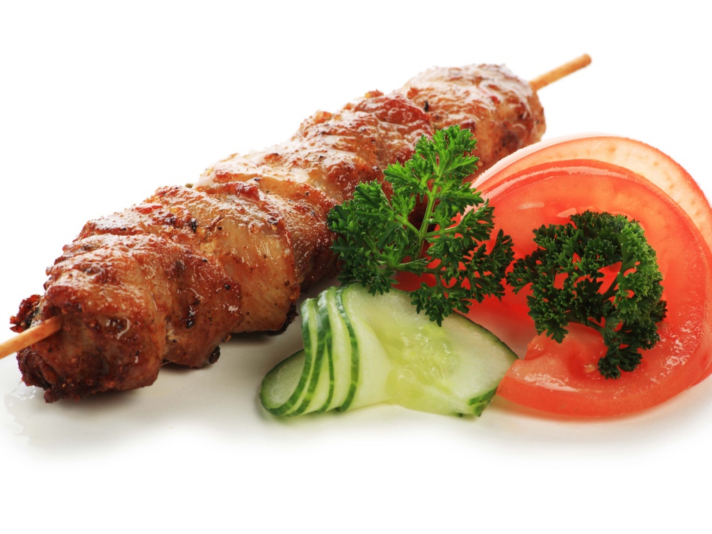 Шашлык с огурцами, помидорами и зеленью на белом фоне