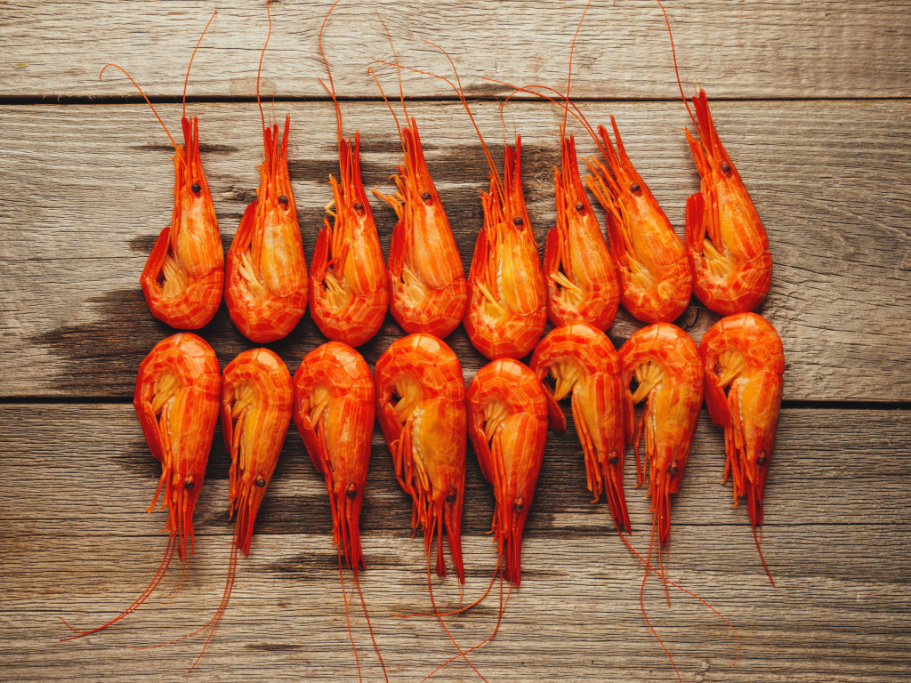 Красные вареные креветки на деревянном столе