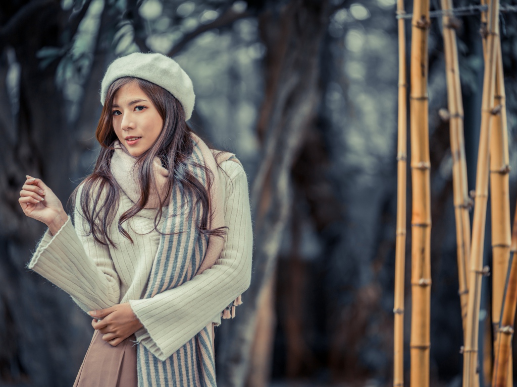 Красивая девушка азиатка в пальто с беретом на голове