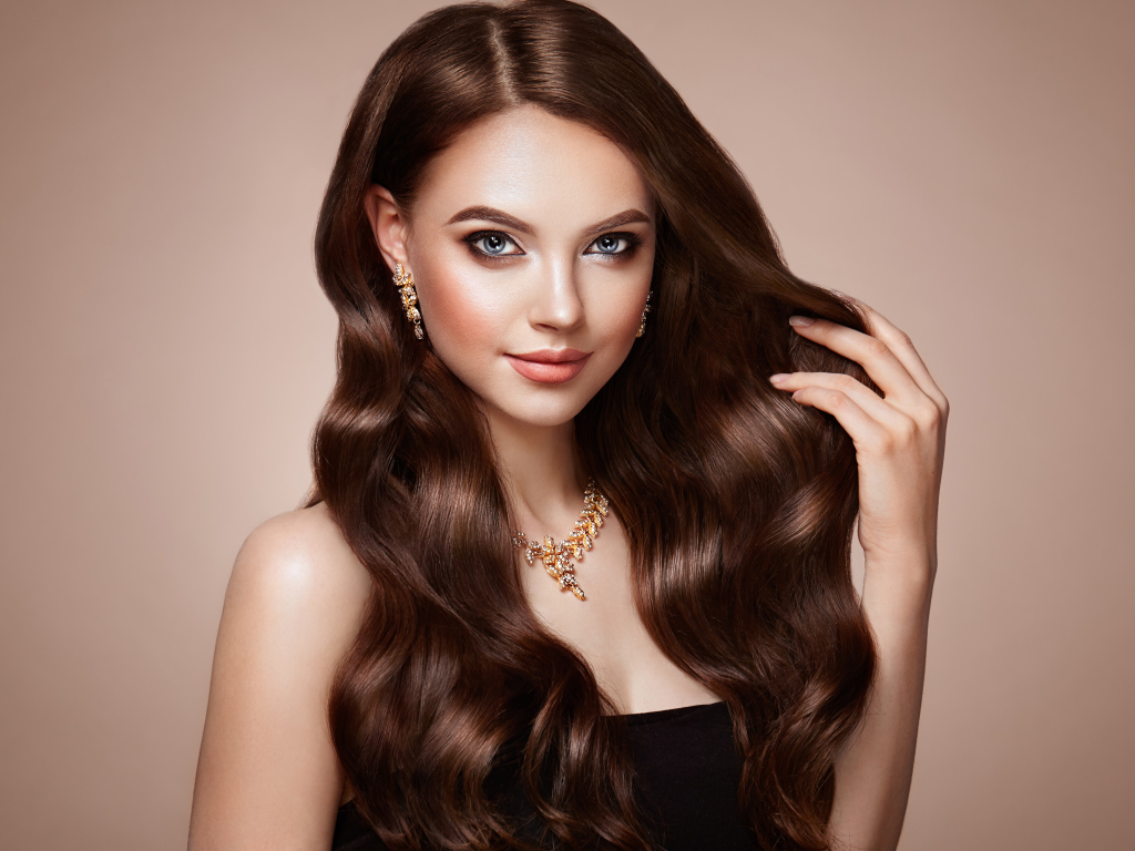 Красивая голубоглазая длинноволосая девушка шатенка с золотым украшением на шее 