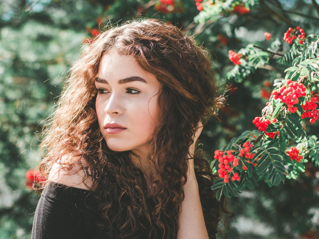 Красивая шатенка у ветки с красными ягодами рябины