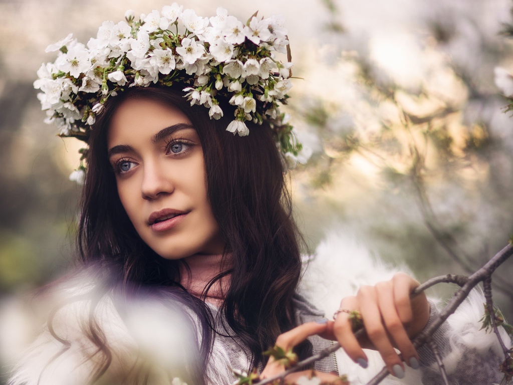 Красивая брюнетка с венком из цветов вишни на голове