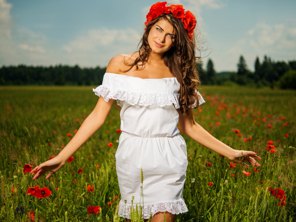 Красивая девушка в белом платье с венком из красных маков на голове 