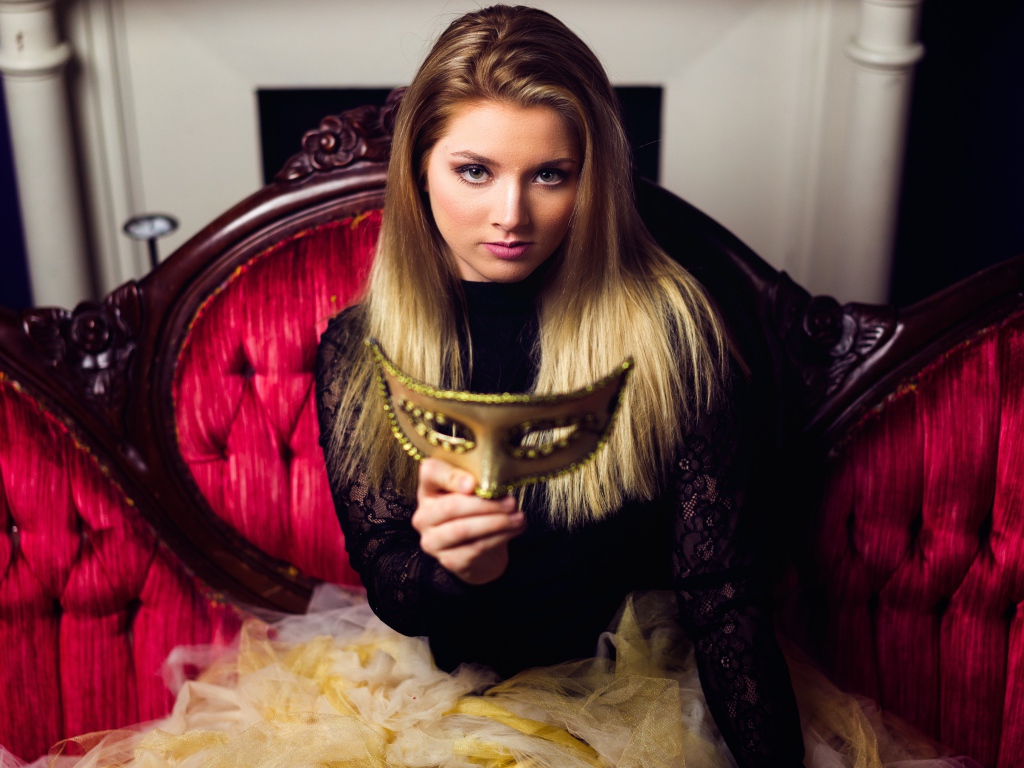 Красивая девушка с маской в руках