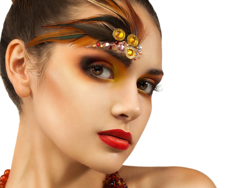 Красивая девушка с ярким макияжем и стразами на лице