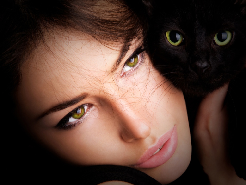 Красивая зеленоглазая девушка с черной кошкой