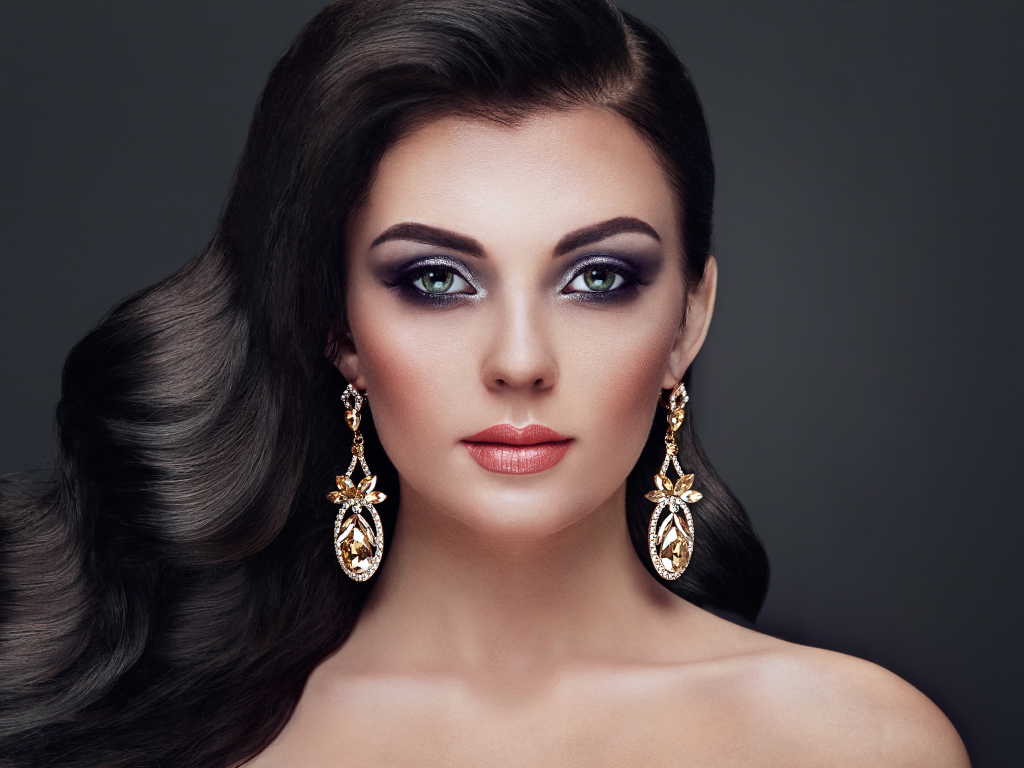 Красивая длинноволосая девушка с ярким макияжем и длинными серьгами