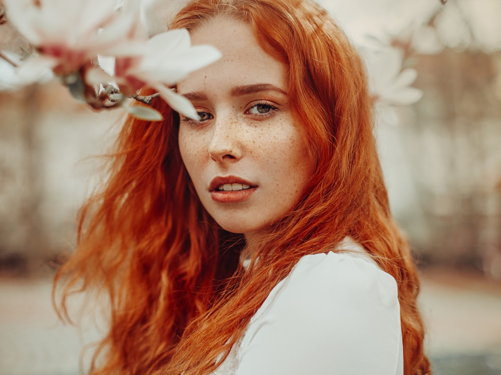 Красивая рыжеволосая девушка с веснушками на лице