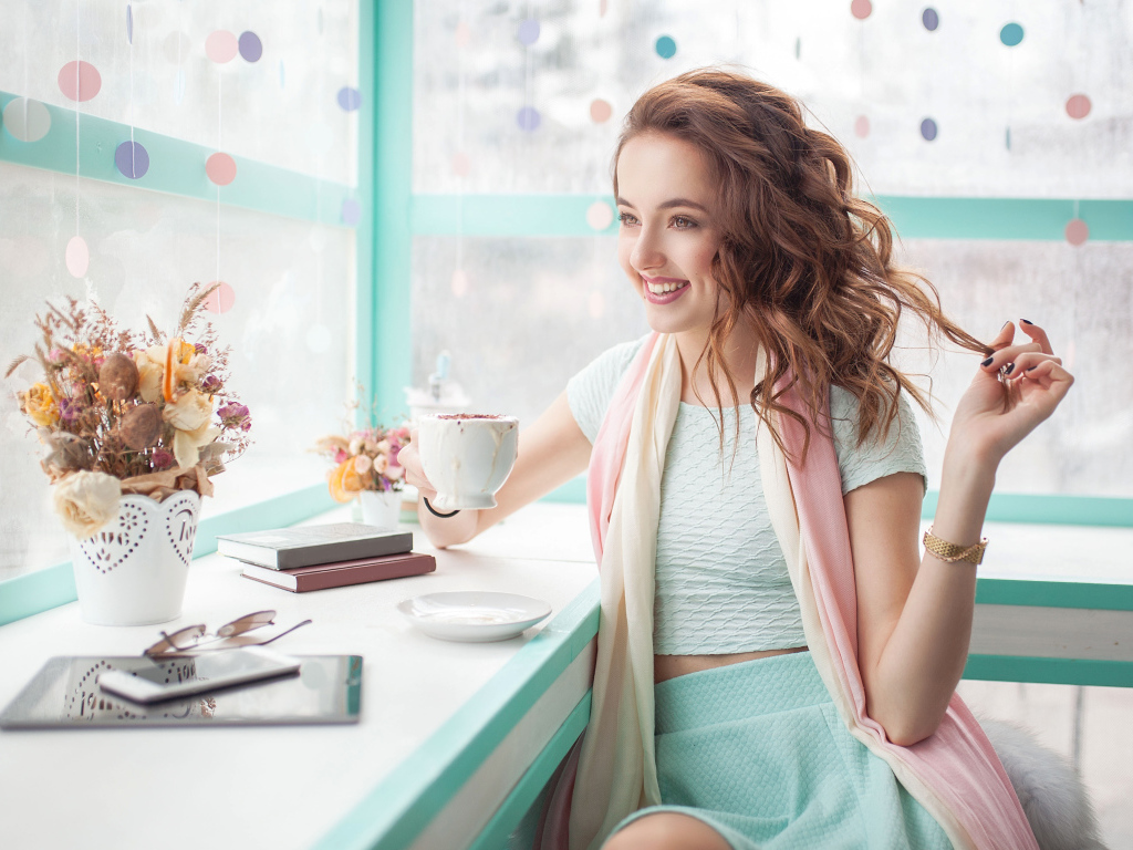 Красивая улыбающаяся девушка шатенка с чашкой кофе