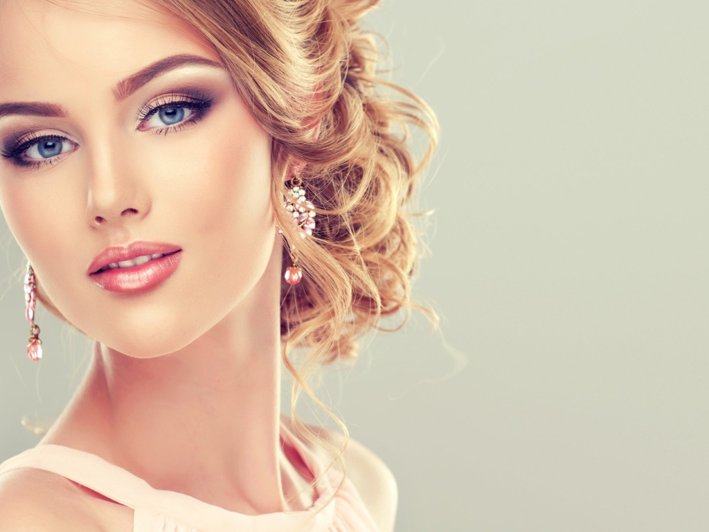 Красивая стильная голубоглазая девушка с красивым макияжем и прической