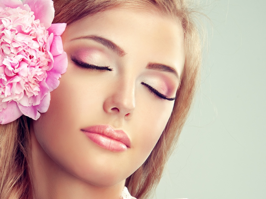 Красивая нежная молодая девушка с розовым цветком пиона в волосах 