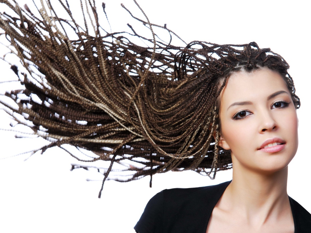 Девушка с прической косичками на голове на белом фоне